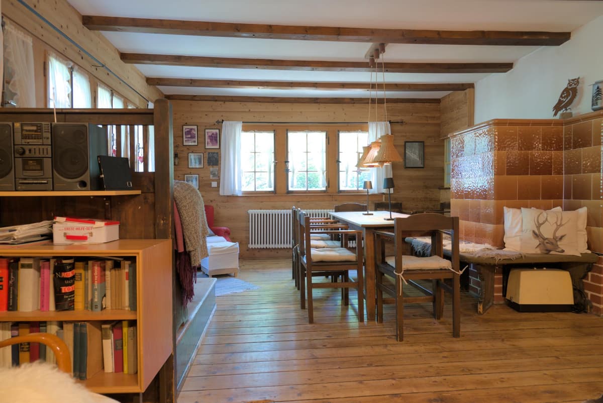 Wohnzimmer mit Ofen und Esstisch